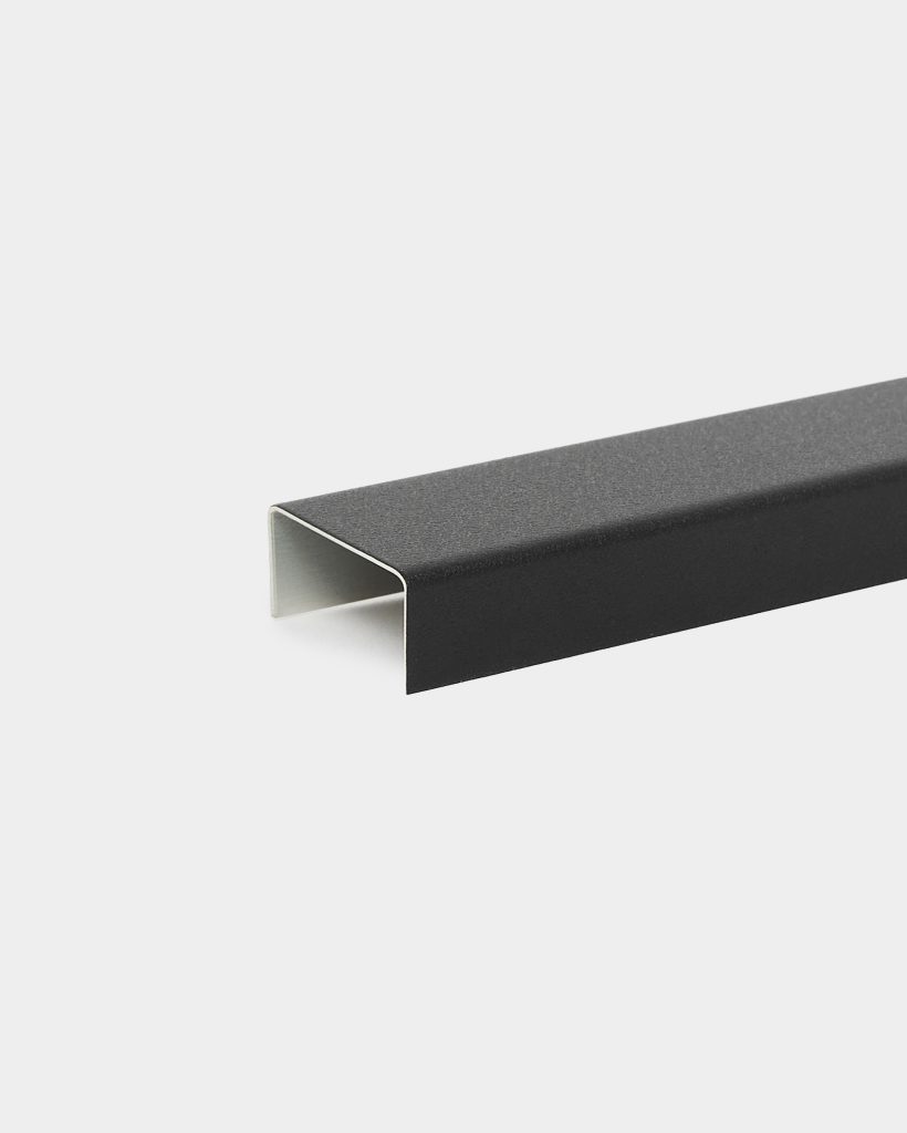 WoodUpp black U-shaped aluminium profile trim with a matte, textured finish; the hollow rectangular channel shows the white inner surface and crisp folded edges. The single WoodUpp edge profile lies diagonally on a light background, highlighting its clean, modern form.