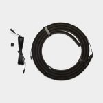 WoodUpp product image showing a coiled dark brown flat LED light strip secured with two fabric straps, alongside a long black connection cable with molded connectors, a short pigtail lead and a small square adhesive mounting pad — a compact under-cabinet or shelf lighting accessory kit.