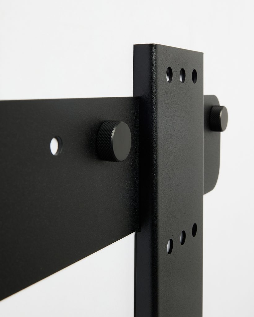 Close-up of WoodUpp black powder-coated steel mounting bracket and vertical support, featuring three punched holes and two knurled adjustment knobs. The image shows the robust L-shaped hardware and flat strap from WoodUpp, highlighting textured finish, precise holes and screw-in thumb bolts for secure assembly.