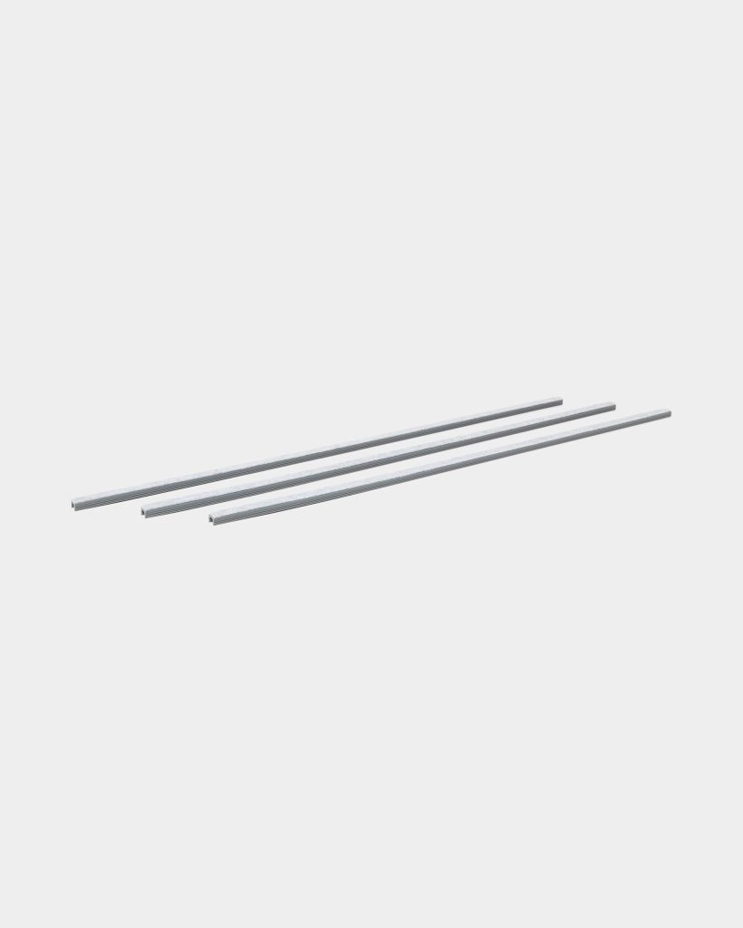 WoodUpp: three slim silver metal guide rails from WoodUpp, shown parallel on a light background. Each long, straight rail has a narrow rectangular profile with a shallow groove along its length and a clean, brushed finish, suggesting use as guide or mounting strips.